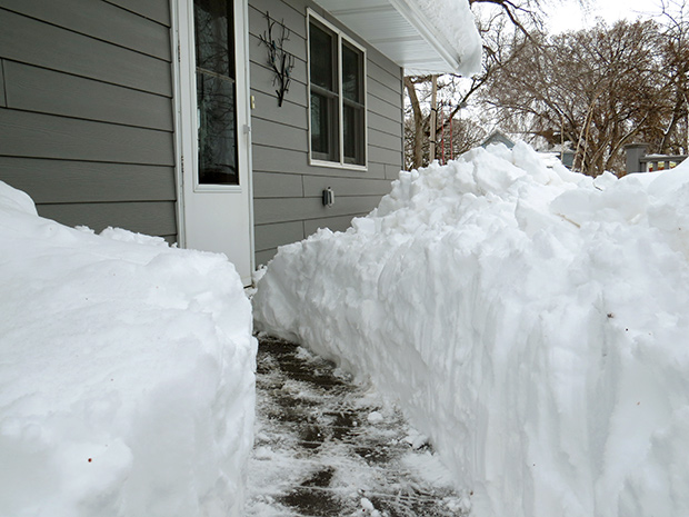 Sidewalk snow tunnel in South Dakota on April 12, 2019 Photo of a cleared sidewalk lined by a tunnel of snow several feet deep leading to the door of a house in South Dakota