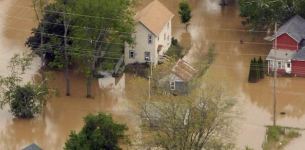 aerial photo of flood waters surrounding a house
