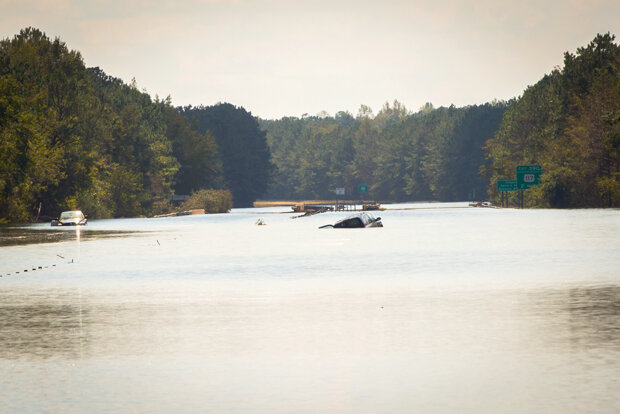 Photo of major flooding on I-40 in NC, with a stranded car