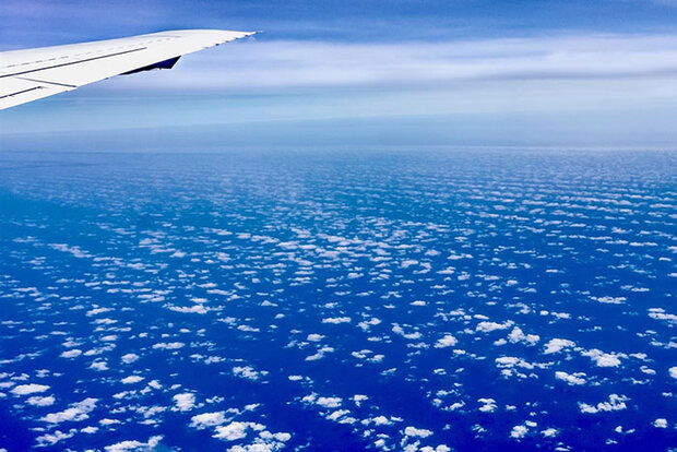 Plane wing over clouds