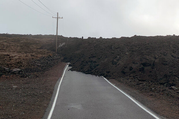 Fresh lava blocks one-lane road and engulfs bottom of utility pole