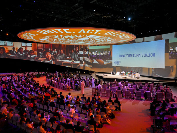 International youth gather in an arena to discuss and hear from leaders at the Dubai Youth Climate Dialogue.